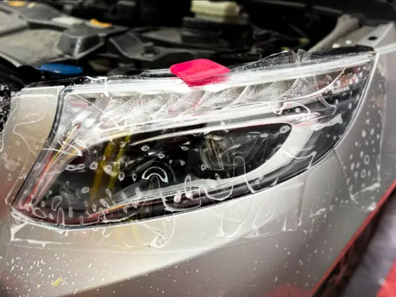 Far Mercedes în timpul aplicării foliei transparente de protecție