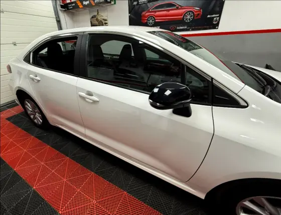 Toyota Corolla albă cu folie fumurie pe geamurile din spate, în atelier