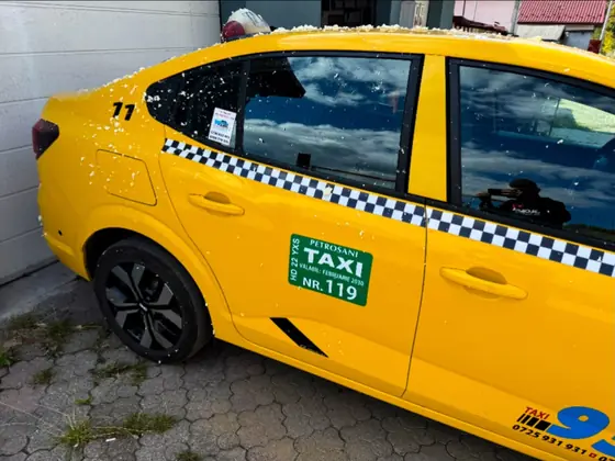 Dacia Logan taxi galben colantat cu grafica firmei de taxi